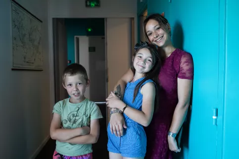 Une jeune femme en service civique avec deux enfants dans un couloir de la MECS La Valbourdine (Toulon, 83)