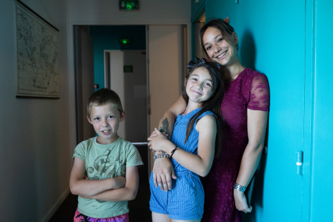 Une jeune femme en service civique avec deux enfants dans un couloir de la MECS La Valbourdine (Toulon, 83)