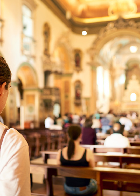 Jeune femme, de dos, entrant dans une église 