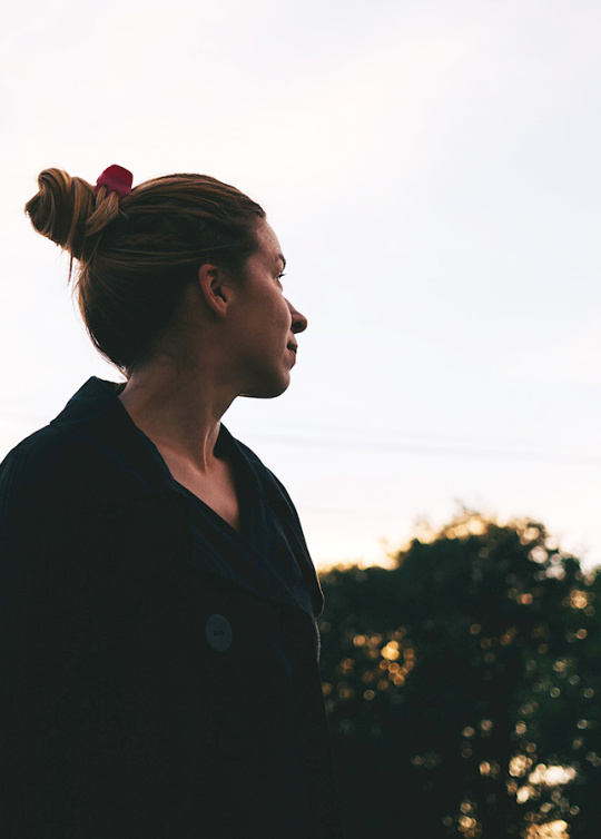 Jeune femme regardant le ciel, lumière de fin de journée