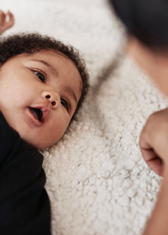 Photo d'une bébé allongé regardant sa maman