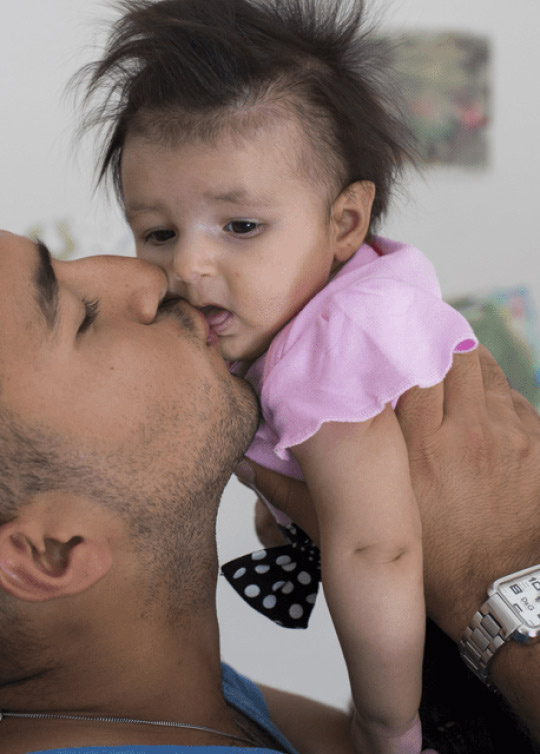 Jeune enfant dans les bras de son père