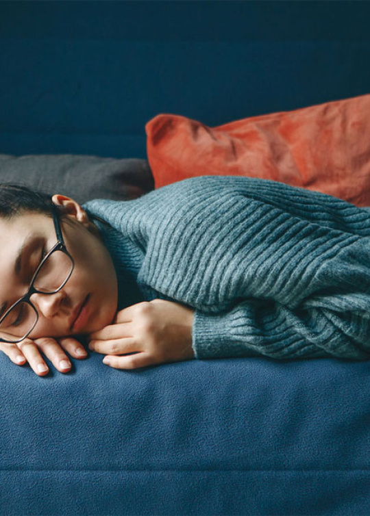 Illustration de la fatigue chez les jeunes, jeune fille dormant sur un canapé