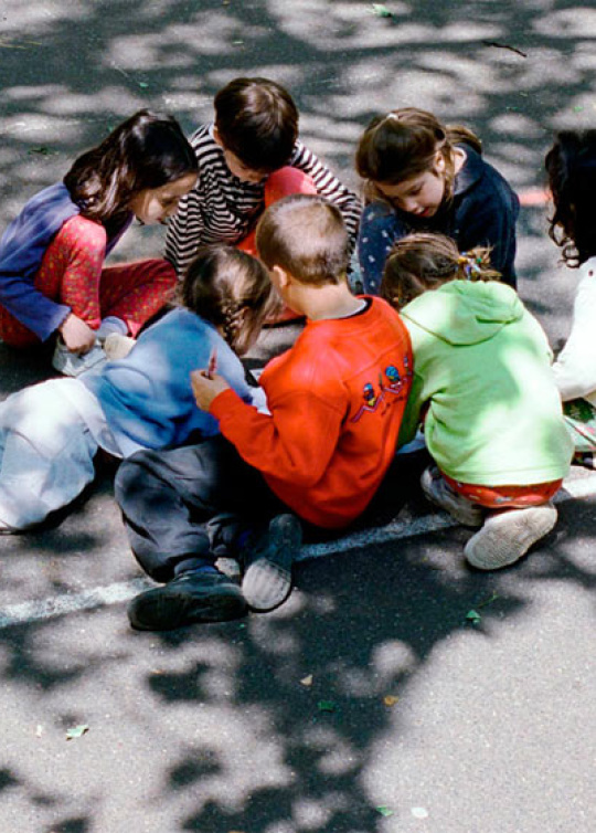 groupe d'enfants assis dans la cour de récréation