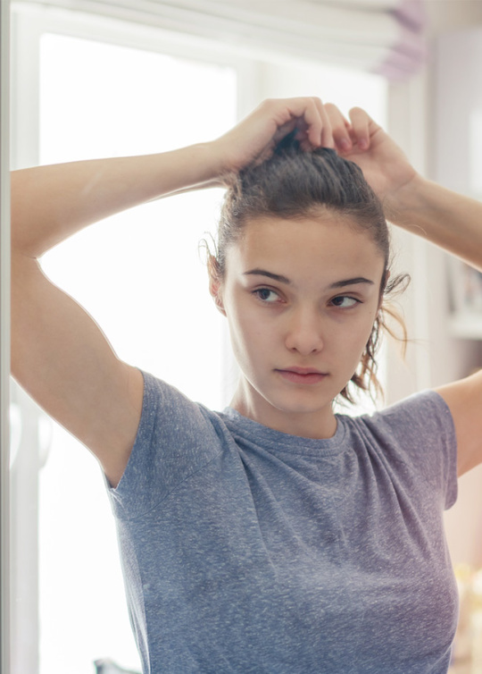 Jeune fille se regardant dans la glace de sa chambre