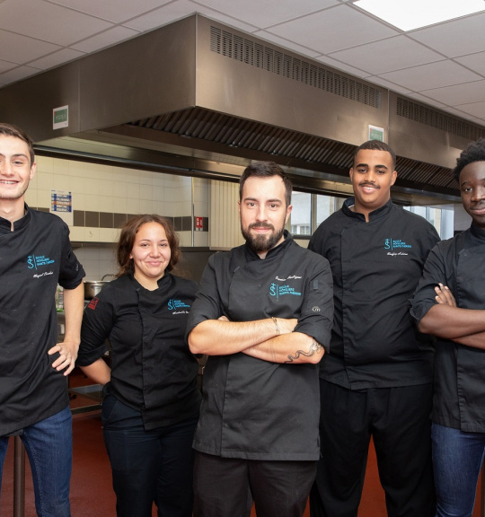Ecole hôtelière Sainte-Thérèse. 4 élèves en formation cuisine posent avec Quentin Soulignac – enseignant formateur cuisine
