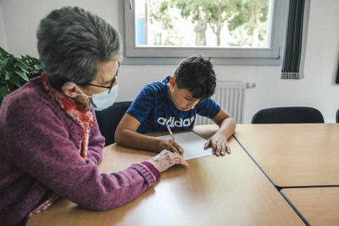 Eddy pendant l'aide au devoir à la maison d'enfants à caractère social (MECS) Saint-François d'Assise à Strasbourg avec une bénévole, Michèle