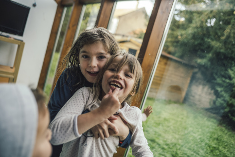 Lucie, au centre et en situation de handicap, reçoit un bisous de sa sœur à la Maison d'enfants Saint-François d'Assise