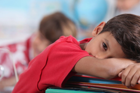 Enfant en classe posant sa tête sur la table