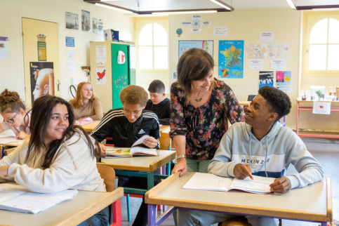 Salle de classe au collège Saint-François du Château des Vaux avec des jeunes et un professeur.