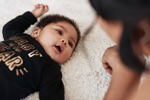 Photo d'une bébé allongé regardant sa maman