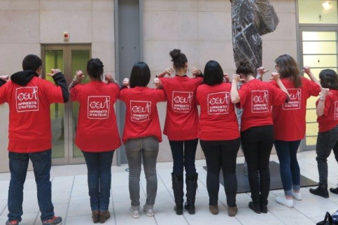 8 jeunes en service civique de dos montrant leur tee-shirt sur lequel est inscrit "Apprentis d'Auteuil"