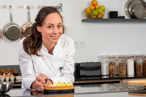 Nina Métayer dans son laboratoire de pâtisserie devant une de ses créations