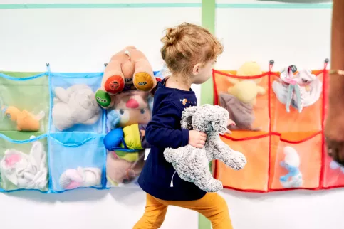 petite fille dans une créche avec son doudou