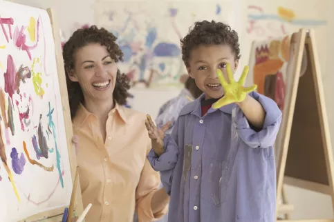 Institutrice avec un enfant en atelier de peinture