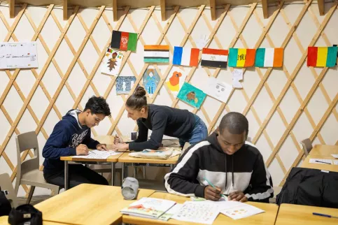 Deux jeunes adolescents dans une salle de classe avec une éducatrice