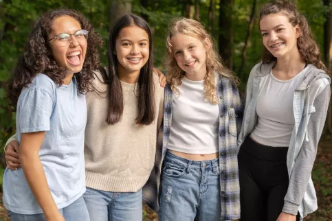 Quatre adolescentes sourient, de face