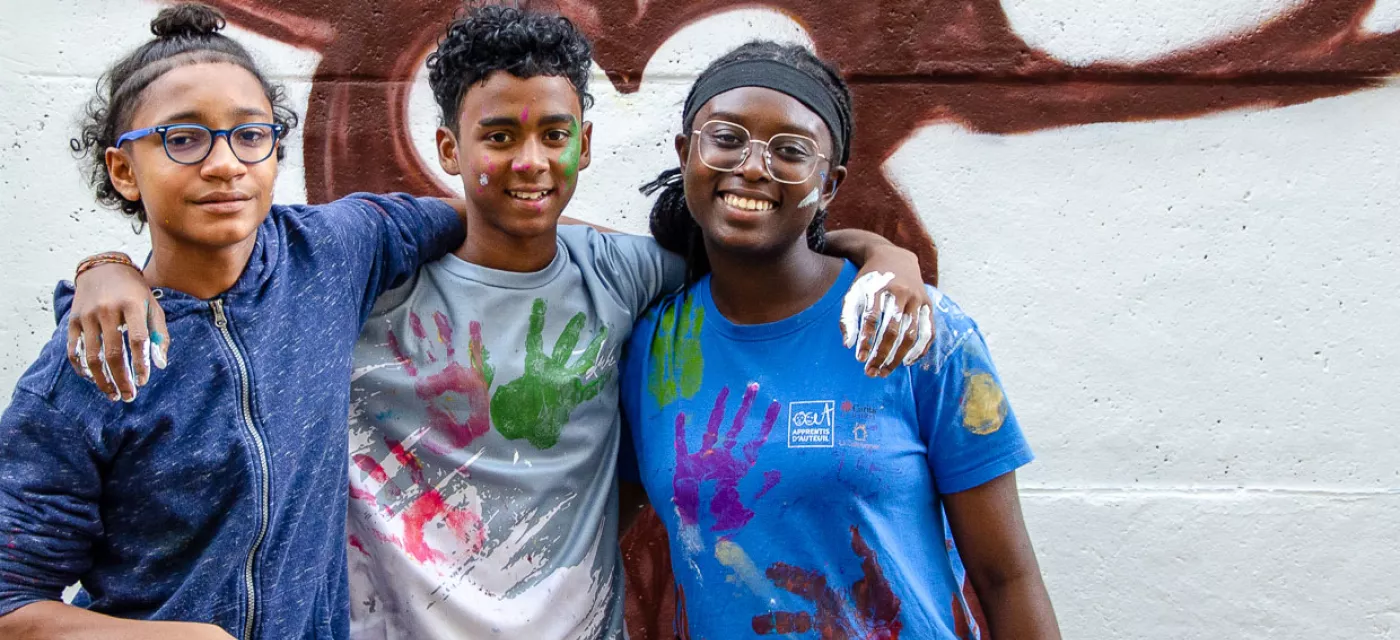 Evans, Nigel et Paris posant devant l'arbre peint sur la fresque