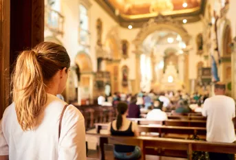 Jeune femme, de dos, entrant dans une église 