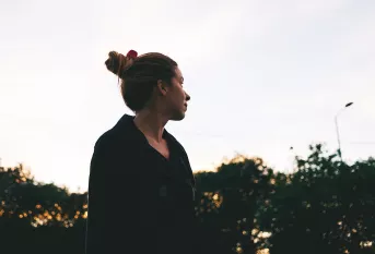 Jeune femme regardant le ciel, lumière de fin de journée