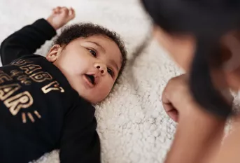 Photo d'une bébé allongé regardant sa maman