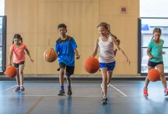 Elèves jouant au basket dans un gymnase