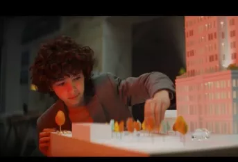 le visuel représente un adolescent finalisant une maquette d'immeuble