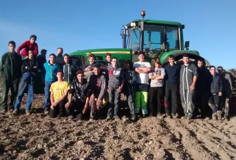 Des élèves du Lycée professionnel agricole Val de Drôme posent dans un champ devant un tracteur