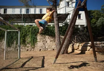Fillette de la MECS La Valbourdine sur une balançoire dans le jardin
