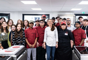Nina Métayer au milieu d'un groupe de jeunes dans le laboratoire