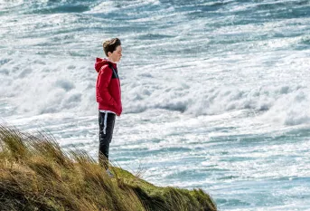 Un jeune adolescent face à la mer