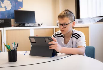 Collège Nouvelle Chance - Batiste travaille sur une tablette numérique