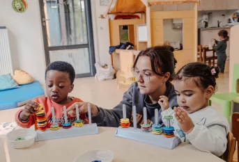 Atelier motricité fine pour les petits grâce un jeu de précision dans une crèche