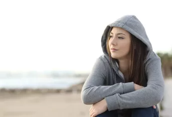 Jeune fille sur la plage, pensive