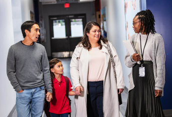 Des parents avec leur enfant rencontre une professeur au sein de l'école