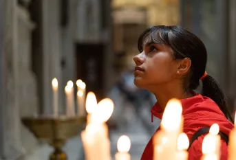 Une jeune fille priant dans une église