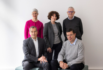 5 personnes, 2 assises, 3 debout derrière. 