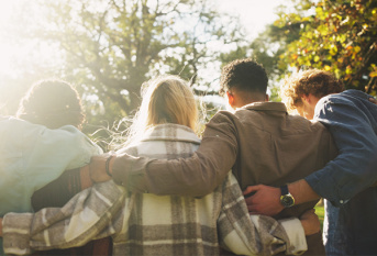 Groupe d'amis de dos, illustrant la force d'être à plusieurs