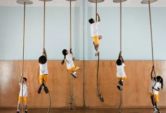 Illustration du déterminisme social, élèves grimpant à la corde à noeuds