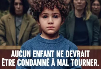 Un petit garçon d'environ 4 ans est menotté dans un tribunal. On voit derrière lui le public un peu flouté. Texte : Aucun enfant ne devrait être condamné à mal tourner. Apprentis d'Auteuil soutient chaque année 40 000 jeunes en difficulté pour qu'ils puissent se bâtir un avenir meilleur. Faites un don sur www.apprentis-auteuil.org