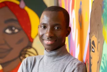 Jeune garçon souriant devant une fresque murale