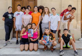 Violette Dorange pose devant le collège au milieu d'une quinzaine de jeunes élèves