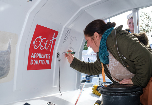 Une maman de La maison des familles du Havre écrit un mot dans la cabine du bateau de Violette Dorange 