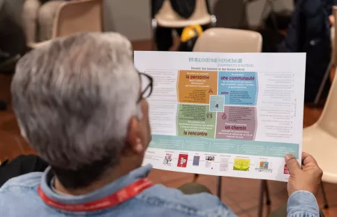 un adulte vu de dos lit un document sur lequel on lit notamment "projet éducatif"