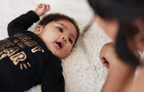 Photo d'une bébé allongé regardant sa maman