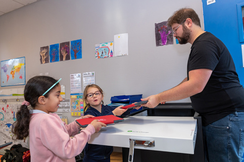 Samy Blin, professeur des écoles, à l'école Saint-Gabriel de Bagneux distribue les tablettes numériques aux élèves