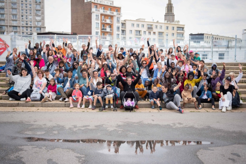 Photo de groupe de familles et enfants les mains levées