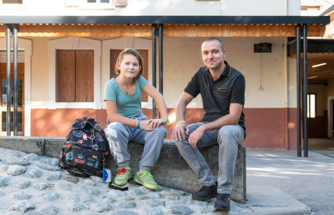 Léonie, jeune élève, et Mickaël, éducateur sont assis côte à côte dans la cour du collège.