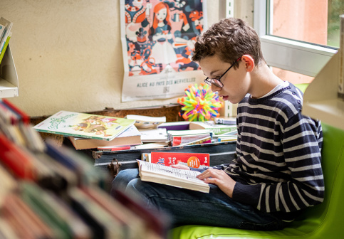 Adolescent lisant à la bibliothèque 