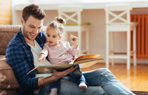 Un papa et sa petite fille lisent ensemble